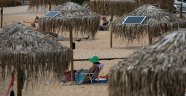 Atina plajlarında güneş enerjili telefon sarj şemsiyeleri